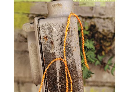 Power Cover - strand of yarn hanging over a rusted piece of metal